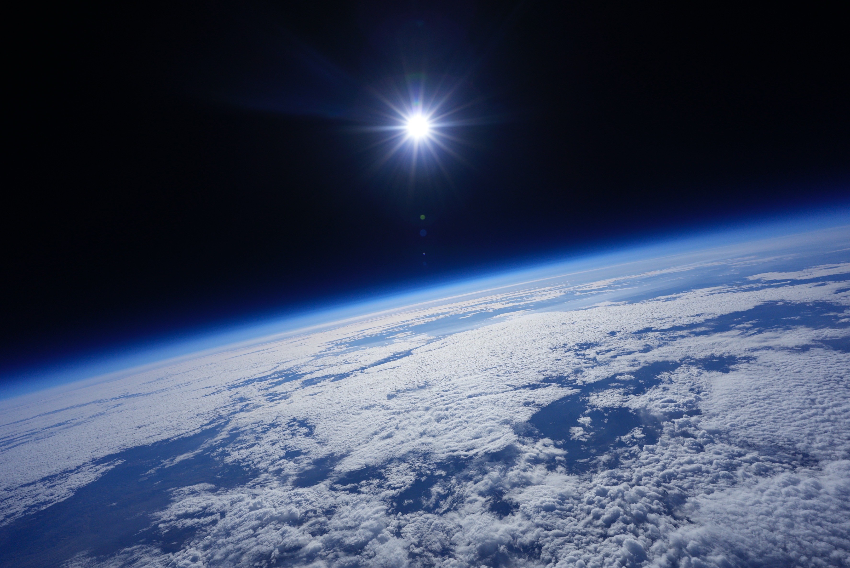 view of the Earth from a space-like perspective, with the sun in the frame