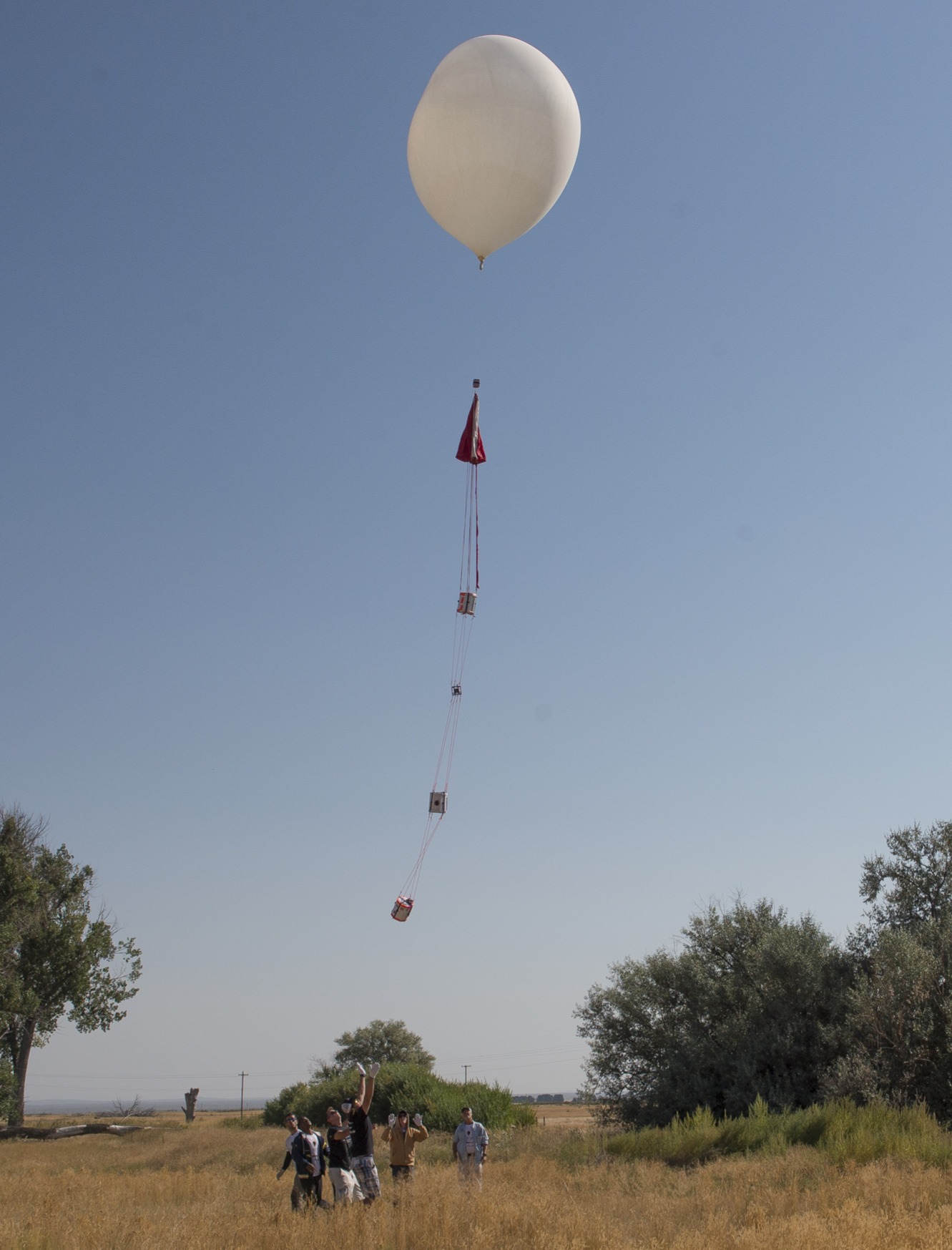 A balloon being released with a trail of payloads below it