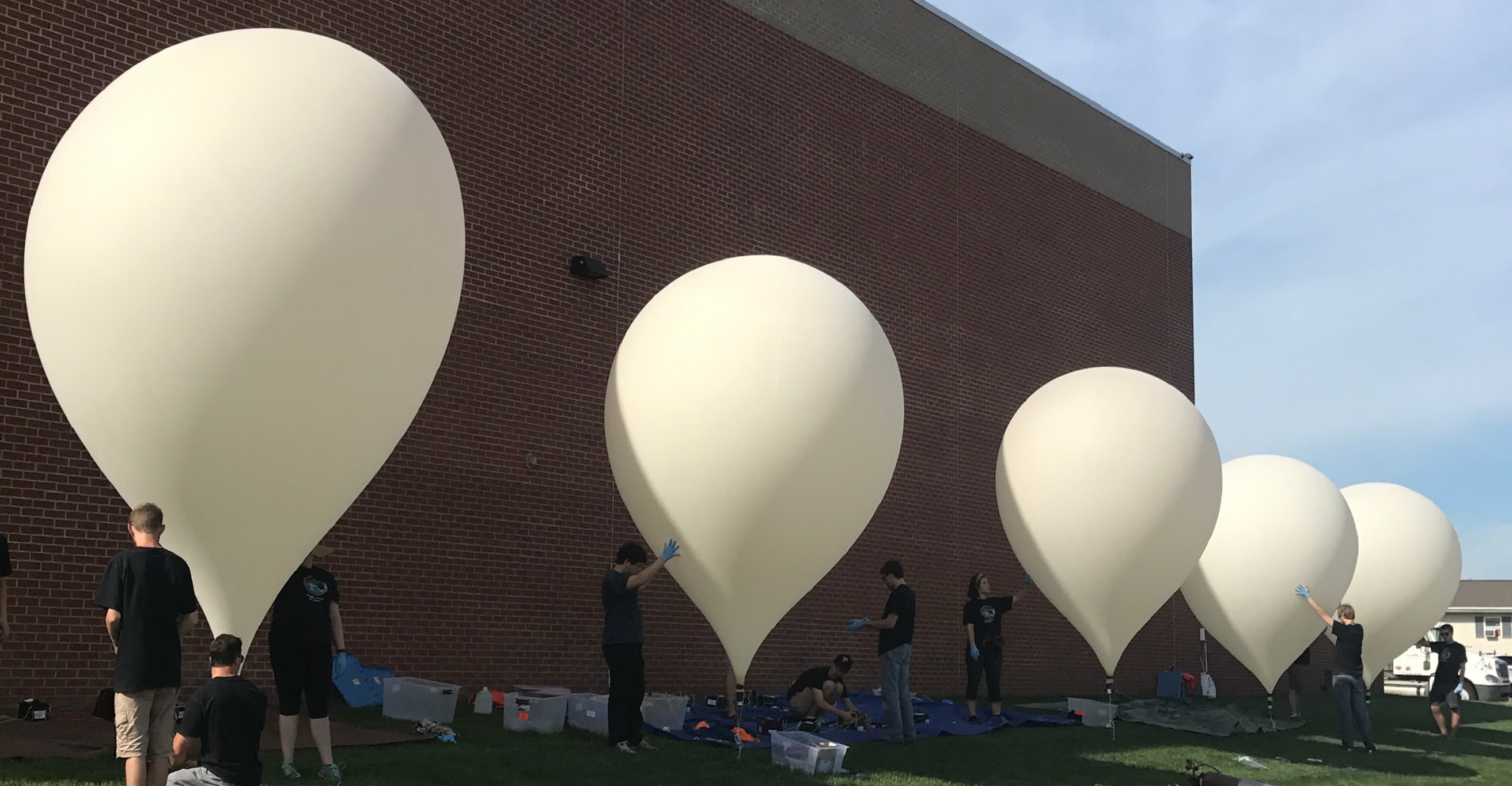 5 balloons being prepared for launch at once