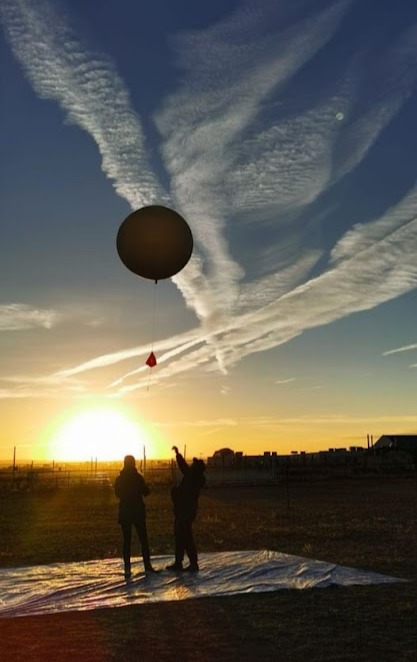 The silhoette of a balloon over the sunrise
