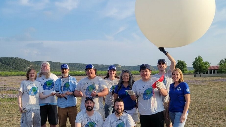 The borealis team together holding an inflated balloon
