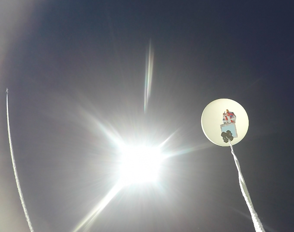 A jet passes by a balloon mid-flight