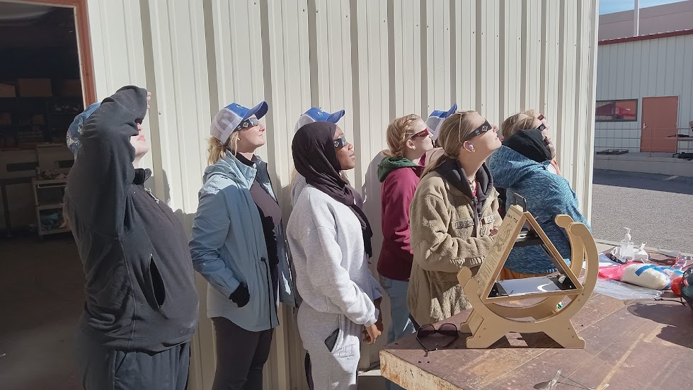 A groupd of people watching the solar eclipse wearing protective eye wear