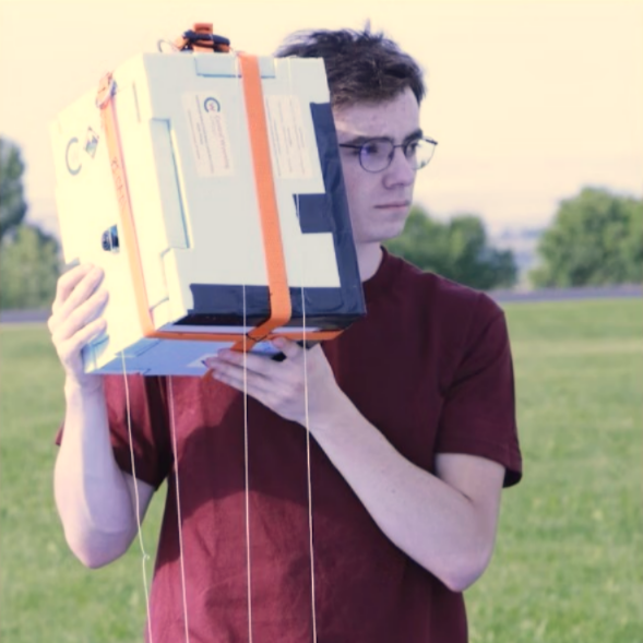 A student holding a box containing a payload