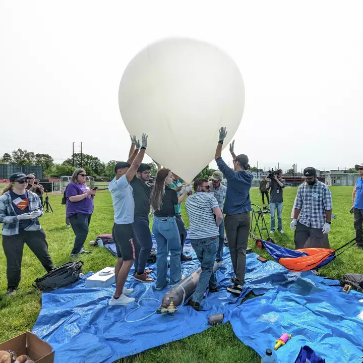 A team of people surrounding a balloon