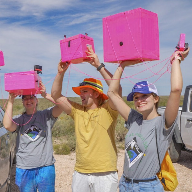 People holding pink payloads above their heads