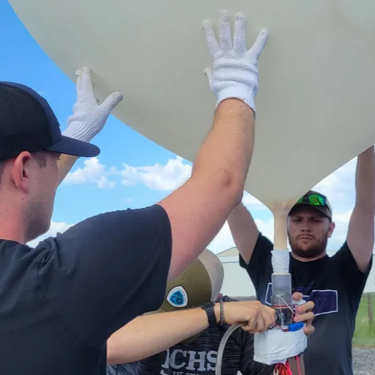 A group of people filling a balloon