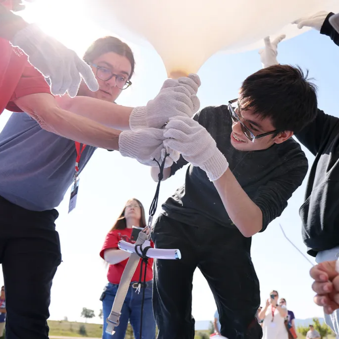 A team filling a balloon