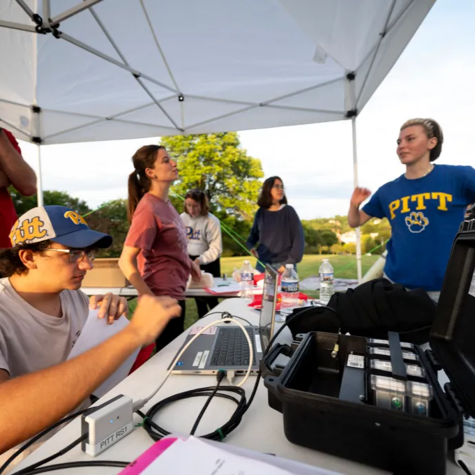 A group of people surrounding the ground station