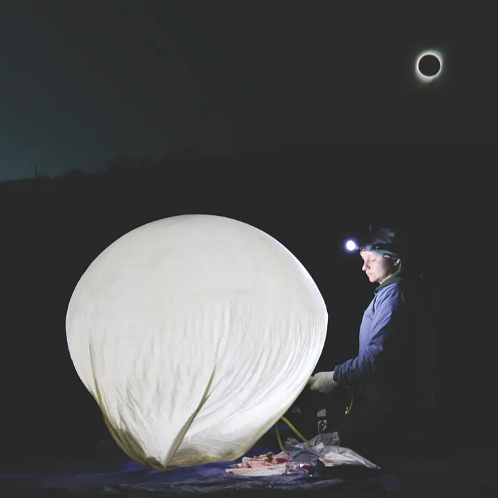 A balloon being filled in the dark of the eclipse