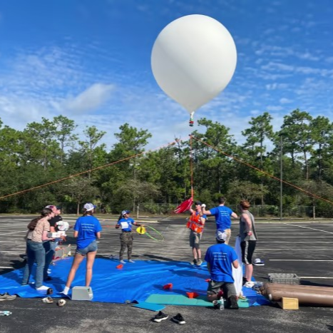 A team of people working to release to a balloon