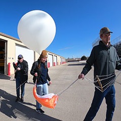 A team carrying a balloon and it's payloads