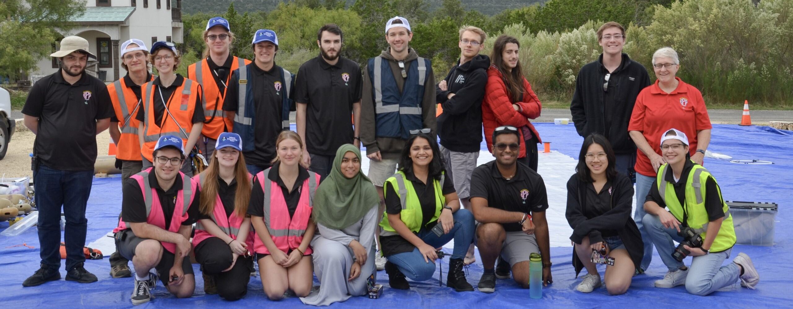 20 people are posing at their balloon launch site